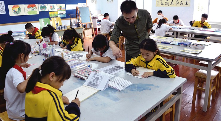中国小学美术教室里，学生们分组进行绘画创作
